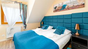 a blue and white bedroom with a large bed at Wonder Home - Domki górskie z kominkami na kameralnym osiedlu - plac zabaw na terenie kompleksu in Karpacz
