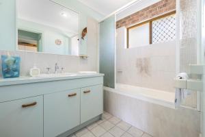 a white bathroom with a sink and a shower at Sandy Surfer - Tweed Coast Holidays in Cabarita Beach