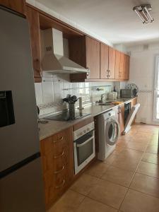 a kitchen with a washing machine and a washer at Spacious family friendly 3 bedroom home B' Pueblo - swimming pool - games room & sunny terrasse in Benalmádena