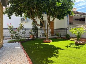a garden with a tree in the middle of it at Villa Biznaga in Rincón de la Victoria