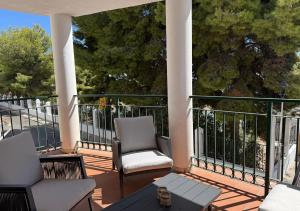 a patio with two chairs and a table on a balcony at Spacious family friendly 3 bedroom home B' Pueblo - swimming pool - games room & sunny terrasse in Benalmádena
