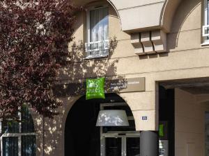 a building with a green sign in front of a window at ibis Styles Paris Porte de Versailles - Mairie d'Issy in Issy-les-Moulineaux