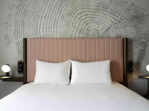 - un lit avec 2 oreillers blancs dans une chambre dans l'établissement ibis Styles Paris Porte de Versailles - Mairie d'Issy, à Issy-les-Moulineaux
