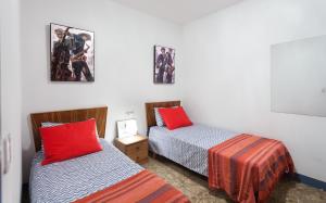 ブラナスにあるVivalidays Joan - Blanesの赤い枕のベッド2台が備わる客室です。