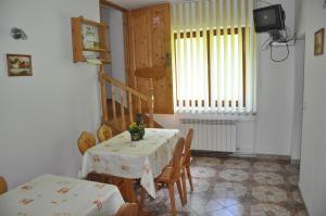 a dining room with a table and chairs and a television at Agroturystyka Zagroda in Podobin