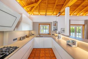 a kitchen with white cabinets and a wooden ceiling at Casa Mi Arcadia in El Paso