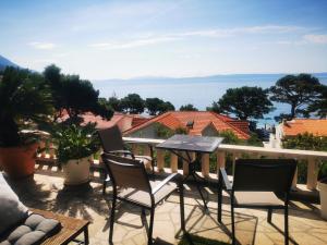 a patio with chairs and a table on a balcony at Relax Terrace apartment with Jacuzzi in Brela