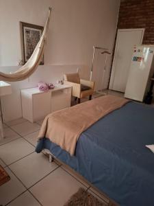Un dormitorio con una cama, un escritorio y una silla. en Branco Por do sol próximo aeroporto, en Porto Alegre