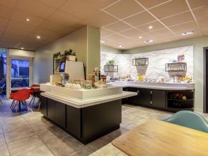 - une cuisine avec un comptoir et un réfrigérateur dans la chambre dans l'établissement ibis La Rochelle Centre Historique, à La Rochelle