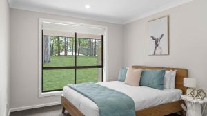 TomerongにあるModern Bush Retreat- Brand New 5BR Tranquil Escapeのベッドと窓のある白い寝室