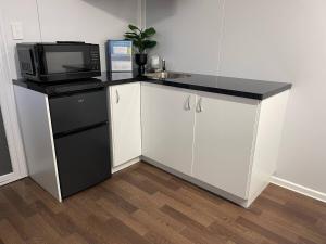 a kitchen with a counter with a microwave and a refrigerator at Wannanup Retreat - Sleeps 2 - Pet Friendly in Wannanup