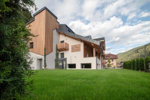 ein Haus mit einem grünen Rasen davor in der Unterkunft El Giof Alpine Home in Pellizzano