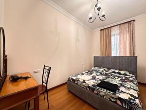 a bedroom with a bed and a table and a desk at Republic square 2 bedroom 2 bathroom in Yerevan