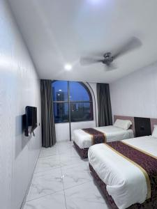 a hotel room with two beds and a window at Hotel LBS in Kuala Lumpur