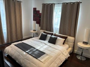 a bedroom with a white bed with pillows and curtains at Knickerbocker 102 in Miami Beach