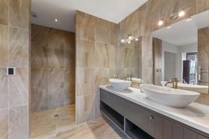 ein Badezimmer mit zwei Waschbecken und einem großen Spiegel in der Unterkunft Lake View Lodge in Taupo Airport