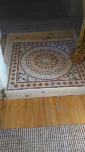 a floor with a tile pattern on it on a wooden floor at Chez Corban in Rosans