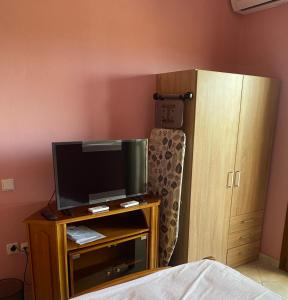 Un dormitorio con un televisor sobre una mesa con un mueble. en Aphrodites Gardens 2, en Ormos Panagias