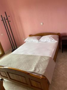 1 cama grande en un dormitorio con paredes rosas en Aphrodites Gardens 2, en Ormos Panagias