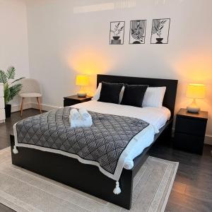 a bedroom with a large bed with two night stands at Modern 3-Bedroom Retreat Just Steps from Wembley Stadium in London