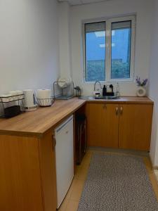 Una cocina con armarios de madera y un fregadero y una ventana. en River Garden House, en Vidin 29 fotos más