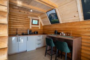 a kitchen in a log cabin with a counter and stools at Wood heaven in Žabljak