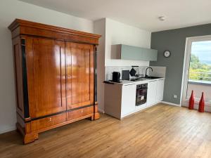 a kitchen with a large wooden cabinet in a room at Premium Penthouse Parkblick in Bad Driburg
