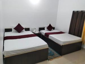 two beds sitting next to each other in a room at Hotel Temple View in Bodh Gaya