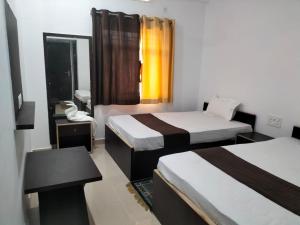een hotelkamer met twee bedden en een spiegel bij Hotel Temple View in Bodh Gaya