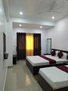 a hotel room with two beds and a window at Hotel Temple View in Bodh Gaya