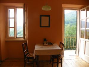 comedor con mesa, sillas y ventana en Appartamento nel Verde, en Mosso Santa Maria