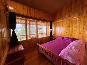Un dormitorio con una cama en una habitación de madera. en Bau's Sapa Homestay, 