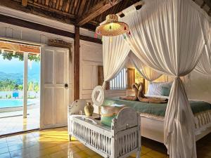 a bedroom with a bed with a canopy at Janur Bungalow in Borobudur +35 photos