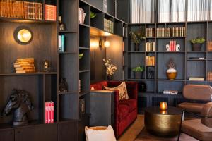 a living room with a red couch and bookshelves at Home Hotel 1624 in Kongsberg