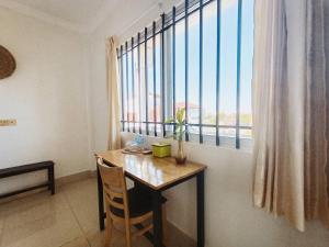 Una habitación con una mesa y una ventana grande. en Grand Apsara Residence, en Siem Reap