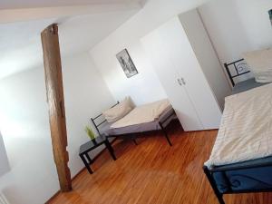 a attic room with two beds and a bench at Stellas Monteurwohnungen in Crimmitschau +15 photos