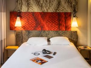 una cama con dos pares de auriculares encima en ibis Toulouse Pont Jumeaux, en Toulouse 86 fotos más