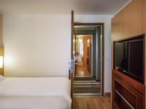 a bedroom with a bed and a flat screen tv at ibis Tours Centre Gare in Tours