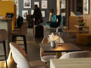 eine Lobby mit einem Tisch und Stühlen und einem Mann im Hintergrund in der Unterkunft ibis Frankfurt Centrum in Frankfurt am Main + 131 Fotos