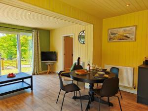 a dining room with yellow walls and a table and chairs at 1 Bed in Conwy 95098 in Llangelynin