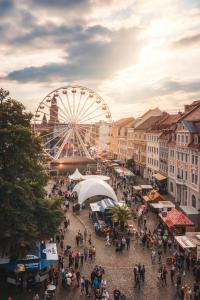 a large crowd of people in a city with a ferris wheel at Hotel Schwibbogen Altstadt & Appartements in Görlitz
