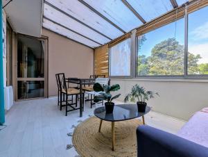 a living room with a table and chairs and windows at Spacious and comfortable apart with terrace in downtown in Evry-Courcouronnes