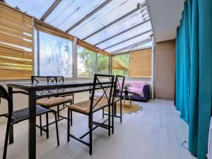 a dining room with a table and chairs and windows at Spacious and comfortable apart with terrace in downtown in Courcouronnes