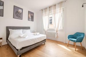 sypialnia z łóżkiem i niebieskim krzesłem w obiekcie Como Centro Luxury Suite a Pochi passi dal Lago w Como