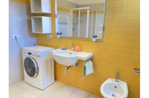 a bathroom with a washing machine and a sink at Misofi' in Bibione