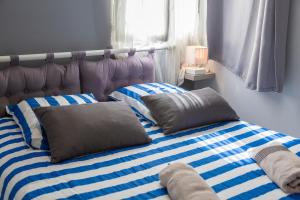Cama con sábanas y almohadas de rayas azules y blancas en L' Eclose Ty Gwen, en Le Guilvinec