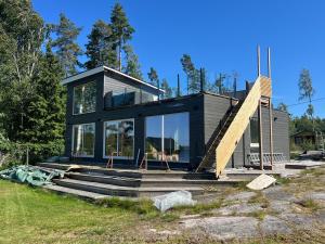 a small house with glass doors and a staircase at Stugan in Kristinehamn