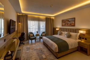 a hotel room with a bed and a desk and chairs at Petra Legacy Luxury in Petra
