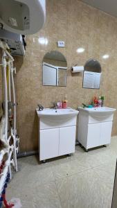 a bathroom with two sinks and two mirrors at L&K Hostel in Toshkent-Passajir Bekati