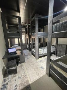 a room with three bunk beds and a laptop on a desk at L&K Hostel in Toshkent-Passajir Bekati